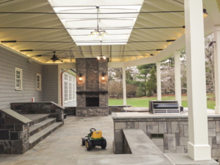 AFTER - GREENWICH CT Roof over patio with a huge custom skylight Build in outdoor kitchen grill and fireplace. Best local Builder