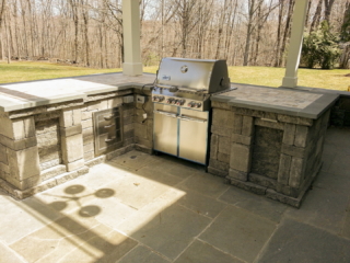 AFTER - GREENWICH CT Roof over patio with a huge custom skylight Build in outdoor kitchen grill and fireplace. Best local Builder