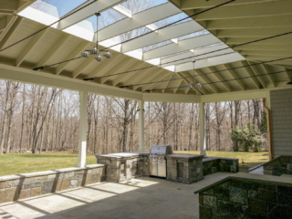 AFTER - GREENWICH CT Roof over patio with a huge custom skylight Build in outdoor kitchen grill and fireplace. Best local Builder