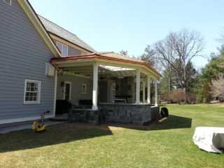 AFTER - GREENWICH CT Roof over patio with a huge custom skylight Build in outdoor kitchen grill and fireplace. Best local Builder